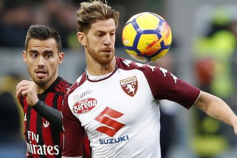 AC Milan's Suso, left, and Torino's Cristian Ansaldi keep their eyes on the ball during a Serie A soccer match at the San Siro stadium in Milan, Italy, Sunday, Nov. 26, 2017. (AP Photo/Antonio Calanni)