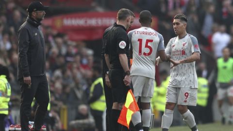 Liverpool's Roberto Firmino, right, walks off after being substituted by Liverpool's Daniel Sturridge during the English Premier League soccer match between Manchester United and Liverpool at Old Trafford stadium in Manchester, England, Sunday, Feb. 24, 2019. (AP Photo/Jon Super)