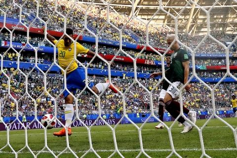 Brazil's Roberto Firmino, left, scores his side's second goal during the round of 16 match between Brazil and Mexico at the 2018 soccer World Cup in the Samara Arena, in Samara, Russia, Monday, July 2, 2018. (AP Photo/Frank Augstein)