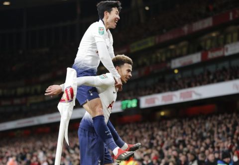 Tottenham's Dele Alli, bottom, celebrates with Tottenham's Son Heung-min after scoring his side's second goal during the English League Cup quarter final soccer match between Arsenal and Tottenham Hotspur at the Emirates stadium in London, Wednesday, Dec. 19, 2018. (AP Photo/Frank Augstein)
