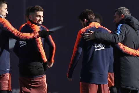FC Barcelona's coach Ernesto Valverde, right, embraces teammate Lionel Messi, second right, during a training session at the Sports Center FC Barcelona Joan Gamper in Sant Joan Despi, Spain, Saturday, Feb. 10, 2018. FC Barcelona will play against Getafe in a Spanish La Liga soccer match on Sunday. (AP Photo/Manu Fernandez)