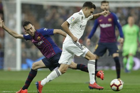 Real defender Sergio Reguilon, right, is challenged by Barcelona midfielder Sergio Busquets during the Spanish La Liga soccer match between Real Madrid and FC Barcelona at the Bernabeu stadium in Madrid, Saturday, March 2, 2019. (AP Photo/Manu Fernandez)