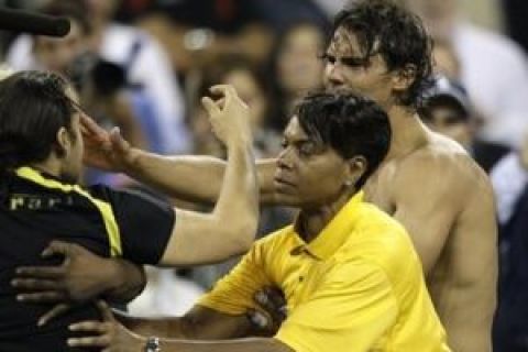 A security guard blocks a man who approached Rafael Nadal of Spain, right, after his quarterfinals win over Gael Monfils of France at the U.S. Open tennis tournament in New York, Wednesday, Sept. 9, 2009. (AP Photo/Charles Krupa)
