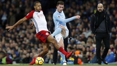Manchester City's Aymeric Laporte, centre, challenges for the ball with West Bromwich Albion's Salomon Rondon during the English Premier League soccer match Manchester City versus West Bromwich Albion at The Etihad Stadium, Manchester, England, Wednesday Jan. 31, 2018. (Martin Rickett/PA via AP)