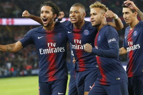 PSG's Kylian Mbappe celebrates with his teammate PSG's Neymar, Marquinhos, left, and Angel Di Maria after scoring his side's fifth goal during the French League One soccer match between Paris-Saint-Germain and Lyon at the Parc des Princes stadium in Paris, France, Sunday, Oct. 7, 2018. (AP Photo/Michel Euler)