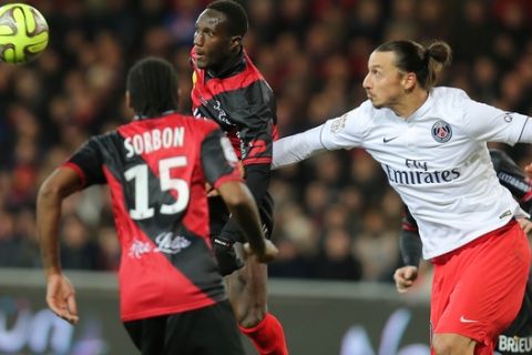 Paris Saint Germain's forward Zlatan Ibrahimovic of Sweden, right, challenges for the ball with Guingamp's french defender Benjamin Brou Angoua during their League One soccer match, in Guingamp, western France, Sunday, Dec. 14 , 2014. Guingamp won 1-0. (AP Photo/David Vincent)