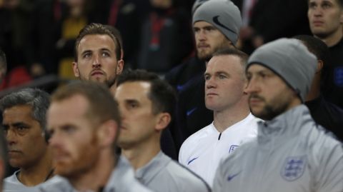 England's Wayne Rooney, center in white, and Harry keane, rear left, listen to the national anthem on the substitutes bench during the international friendly soccer match between England and the United States at Wembley stadium, Thursday, Nov. 15, 2018. (AP Photo/Alastair Grant)