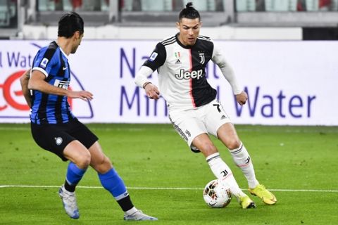 Inter Milan's Antonio Candreva, left, and Juventus' Cristiano Ronaldo battle for the ball during the Serie A soccer match between Inter Milan and Juventus at the Allianz Stadium in Turin, Italy, Sunday March 8, 2020. The match was played to a closed stadium as a measure against coronavirus contagion. (Marco Alpozzi/LaPresse via AP)