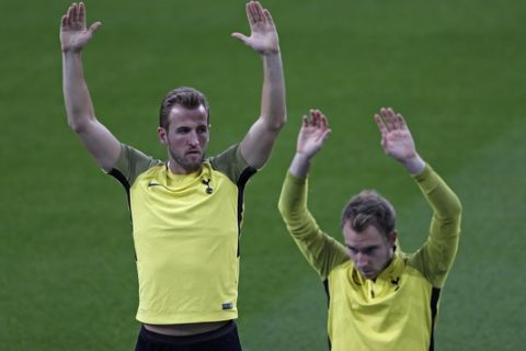 Tottenham's Harry Kane, left, and Christian Eriksen stretch during a training session at the Santiago Bernabeu stadium in Madrid, Monday, Oct. 16, 2017. Tottenham will play a Champions League group H soccer match against Real Madrid on Tuesday 17. (AP Photo/Francisco Seco)