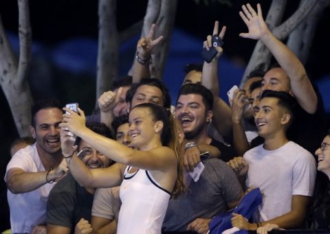 Greece's Maria Sakkari takes a selfie with supporters after she defeated France's Alize Cornet in their second round match at the Australian Open tennis championships in Melbourne, Australia, Thursday, Jan. 19, 2017. (AP Photo/Dita Alangkara)