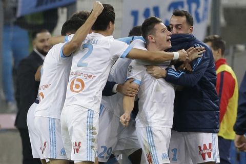 Marseille's Florian Thauvin, second right, celebrates with Marseille's players after scoring during the League One soccer match between Marseille and Paris Saint-Germain, at the Velodrome stadium, in Marseille, southern France, Sunday, Oct. 22, 2017. (AP Photo/Claude Paris)