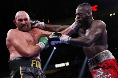 Deontay Wilder, right, and Tyson Fury, of England, trade blows in a heavyweight championship boxing match Saturday, Oct. 9, 2021, in Las Vegas. (AP Photo/Chase Stevens)