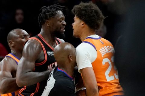 Phoenix Suns forward Cameron Johnson (23) and New York Knicks forward Julius Randle are separated by the referee during the second half of an NBA basketball game, Friday, March 4, 2022, in Phoenix. Randle was ejected after the play as the Phoenix Suns defeated the Knicks 115-114. (AP Photo/Matt York) 