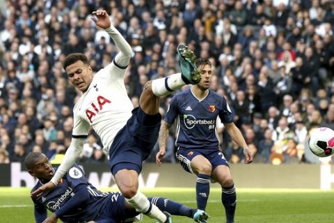 Watford's Christian Kabasele, left, and Tottenham Hotspur's Dele Alli both go to ground in the penalty area, during their English Premier League soccer match at Tottenham Hotspur Stadium in London, Saturday Oct. 19, 2019. (Jonathan Brady/PA via AP)