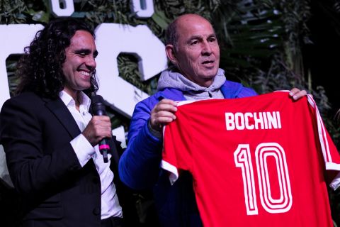 Argentine former Independiente footballer and 1986 FIFA World Cup winner, Ricardo Bochini (R), poses for a photo holding his Independiente jersey, next to Argentine former footballer and sports broadcaster Juan Pablo Sorin, during the presentation of an aircraft called Tango D10S in tribute to Argentien late football star Diego Maradona, in Moron, Buenos Aires province, Argentina, on May 25, 2022. - Some of the 1986 FIFA World Cup champions will travel to the Qatar FIFA World Cup on November, 2022 in the Tango D10S to pay homage to Maradona. (Photo by Tomas CUESTA / AFP)