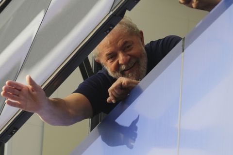 FILE - In this April 7, 2018 file photo, Brazil's former President Luiz Inacio Lula da Silva waves to supporters from a window of the Metal Workers Union headquarters in Sao Bernardo do Campo, Brazil, before he was later jailed for corruption on the same day. Imprisonment has not knocked the former president out of the lead in Brazils upcoming presidential race. He also leads in all proposed runoff combinations. (AP Photo/Nelson Antoine, File)