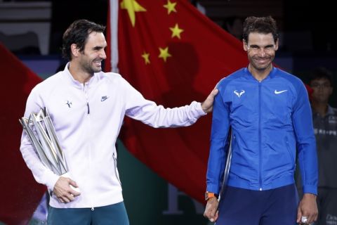 Roger Federer of Switzerland, left, gestures with Spain's Rafael Nadal after winning their men's singles final match in the Shanghai Masters tennis tournament at Qizhong Forest Sports City Tennis Center in Shanghai, China, Sunday, Oct. 15, 2017. (AP Photo/Andy Wong)