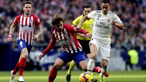 Atletico Madrid's Antoine Griezmann, centre and Real Madrid's Lucas Vazquez challenge for the ball during a Spanish La Liga soccer match between Atletico Madrid and Real Madrid at the Metropolitano stadium in Madrid, Spain, Saturday, Feb. 9, 2019. (AP Photo/Manu Fernandez)