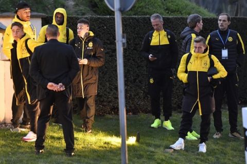Head coach Thomas Tuchel, right, and players of Borussia Dortmund stand outside their team bus after it was damaged in an explosion before the Champions League quarterfinal soccer match between Borussia Dortmund and AS Monaco in Dortmund, western Germany, Tuesday, April 11, 2017.  (AP Photo/Martin Meissner)