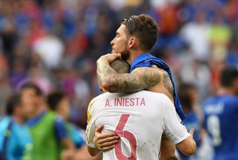 epa05394959 Sergio Ramos of Spain (back) and Andres Iniesta of Spain react after the UEFA EURO 2016 round of 16 match between Italy and Spain at Stade de France in St. Denis, France, 27 June 2016. 

(RESTRICTIONS APPLY: For editorial news reporting purposes only. Not used for commercial or marketing purposes without prior written approval of UEFA. Images must appear as still images and must not emulate match action video footage. Photographs published in online publications (whether via the Internet or otherwise) shall have an interval of at least 20 seconds between the posting.)  EPA/GEORGI LICOVSKI   EDITORIAL USE ONLY