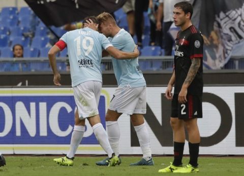 Lazio's Ciro Immobile, center, celebrates with his teammate Senad Lulic after scoring as AC Milan's Davide Calabria looks on, during a Serie A soccer match between Lazio and AC Milan, at the Rome Olympic stadium, Sunday, Sept. 10, 2017. (AP Photo/Alessandra Tarantino)