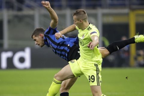 Dinamo Zagreb's Mislav Orsic, right, challenges Atalanta's Remo Freuler, left, during the Champions League group C soccer match between Atalanta and Dinamo Zagreb at the San Siro stadium in Milan, Italy, Tuesday, Nov. 26, 2019. (AP Photo/Luca Bruno)