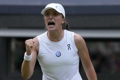 Poland's Iga Swiatek celebrates after beating Switzerland's Belinda Bencic in a women???s singles match on day seven of the Wimbledon tennis championships in London, Sunday, July 9, 2023. (AP Photo/Kirsty Wigglesworth)
