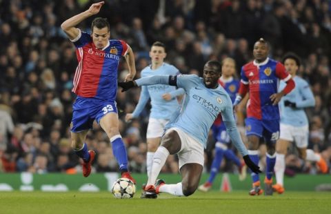 Basel's Kevin Bua, left, challenges for the ball with Manchester City's Yaya Toure during the Champions League, round of 16, second leg soccer match between Manchester City and Basel at the Etihad Stadium in Manchester, England, Wednesday, March 7, 2018. (AP Photo/Rui Vieira)
