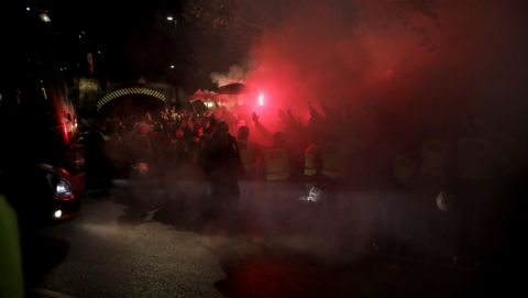Eintracht Frankfurt fans, who are not allowed in the stadium after crowd trouble at their game against Vitoria Guimaraes in October, let off flares as their team's bus arrives, at left, for the Europa League Group F soccer match between Arsenal and Eintracht Frankfurt at the Emirates Stadium, in London, Thursday, Nov. 28, 2019. (AP Photo/Matt Dunham)
