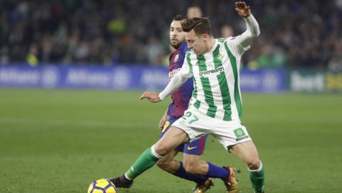 Barcelona's Jordi Alba, behind, and Betis' Francis, front, challenge for the ball during the La Liga soccer match between Barcelona and Betis at the Villamarin stadium, in Seville, Spain on Sunday, Jan. 21, 2018. (AP Photo/Miguel Morenatti)