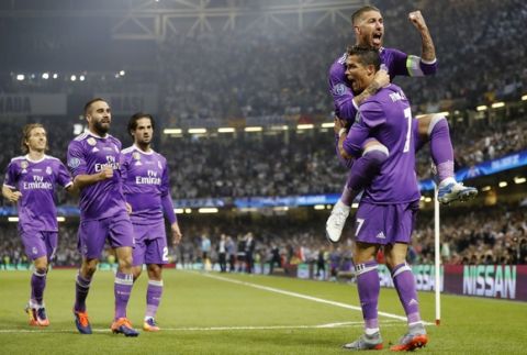 Real Madrid's Cristiano Ronaldo celebrates with Real Madrid's Sergio Ramos, top, after scoring the opening goal during the Champions League final soccer match between Juventus and Real Madrid at the Millennium stadium in Cardiff, Wales Saturday June 3, 2017. (AP Photo/Frank Augstein)