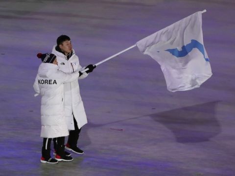 North Korea's Hwang Chung Gum and South Korea's Won Yun-jong walk onto the stage during the opening ceremony of the 2018 Winter Olympics in Pyeongchang, South Korea, Friday, Feb. 9, 2018. (AP Photo/Julie Jacobson)