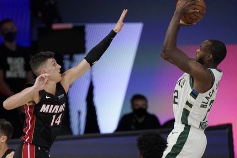 Milwaukee Bucks' Khris Middleton (22) shoots as Miami Heat's Tyler Herro (14) defends in the first half of an NBA conference semifinal playoff basketball game Friday, Sept. 4, 2020, in Lake Buena Vista, Fla. (AP Photo/Mark J. Terrill)