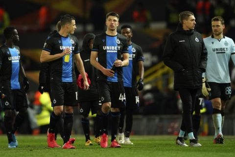 Brugge players walk on the pitch at the end of the round of 32 second leg Europa League soccer match between Manchester United and Brugge at Old Trafford in Manchester, England, Thursday, Feb. 27, 2020. (AP Photo/Dave Thompson)