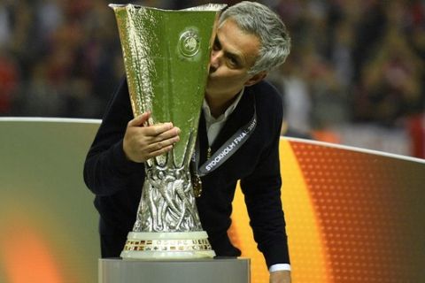 FILE - In this Wednesday, May 24, 2017 file photo United manager Jose Mourinho kisses the trophy after winning the soccer Europa League final between Ajax Amsterdam and Manchester United at the Friends Arena in Stockholm, Sweden. United won 2-0. Jose Mourinho sealed a return to coaching after almost a year out when he was hired as Tottenham manager on Wednesday, a day after the Premier League club fired Mauricio Pochettino. (AP Photo/Martin Meissner, File)