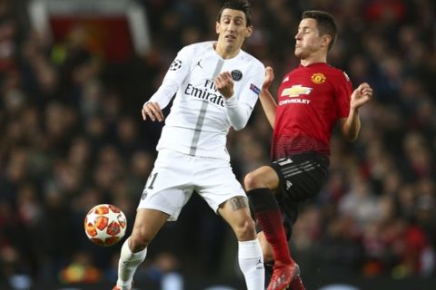 Paris Saint Germain's Angel Di Maria, left vies for the ball with Manchester United's Ander Herrera during the Champions League round of 16 soccer match between Manchester United and Paris Saint Germain at Old Trafford stadium in Manchester, England, Tuesday, Feb. 12,2019.(AP Photo/Dave Thompson)