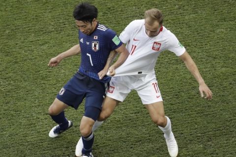 Japan's Gaku Shibasaki and Poland's Kamil Grosicki, right, pull each others' shirts during the group H match between Japan and Poland at the 2018 soccer World Cup at the Volgograd Arena in Volgograd, Russia, Thursday, June 28, 2018. (AP Photo/Themba Hadebe)