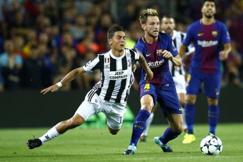 Juventus' Paulo Dybala fights for the ball against Barcelona's Ivan Rakitic during a group D Champions League soccer match between FC Barcelona and Juventus at the Camp Nou stadium in Barcelona, Spain, Tuesday, Sept. 12, 2017. (AP Photo/Manu Fernandez)