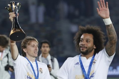 Real Madrid's Luka Modric and Marcelo walk with the trophy after winning the Club World Cup final soccer match between Real Madrid and Al Ain at Zayed Sport City in Abu Dhabi, United Arab Emirates, Saturday, Dec. 22, 2018. (AP Photo/Hassan Ammar)