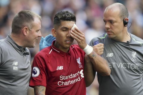 Liverpool's Roberto Firmino, holds a patch over his eye after he received a treatment during the English Premier League soccer match between Tottenham Hotspur and Liverpool at Wembley Stadium in London, Saturday Sept. 15, 2018. (AP Photo/Tim Ireland)