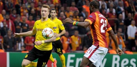 Dortmund's German midfielder Marco Reus (L) vies for the ball with Galatasaray's Cameroonian defender Aurelien Chedjou (R) during the UEFA Champions League Group D football match between Galatasaray and Borrusia Dortmund on October 22, 2014 at the Turk Telecom Arena in Istanbul. AFP PHOTO /OZAN KOSE        (Photo credit should read OZAN KOSE/AFP/Getty Images)