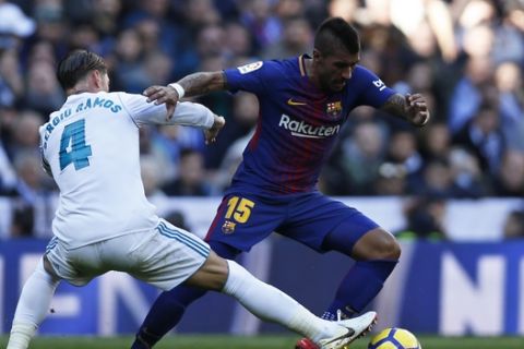 Barcelona's Paulinho fights for the ball with Real Madrid's Sergio Ramos, left, during the Spanish La Liga soccer match between Real Madrid and Barcelona at the Santiago Bernabeu stadium in Madrid, Spain, Saturday, Dec. 23, 2017. (AP Photo/Francisco Seco)