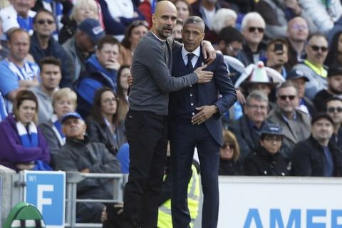 Manchester City coach Pep Guardiola and Brighton manager Chris Hughton, right, embrace each other during the English Premier League soccer match between Brighton and Manchester City at the AMEX Stadium in Brighton, England, Sunday, May 12, 2019. (AP Photo/Frank Augstein)