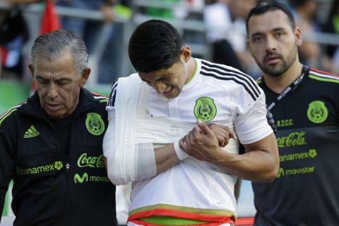 Mexico forward Alan Pulido, center, is taken off the pitch by trainers after he suffered an injury in the second half of an international friendly soccer match against Paraguay, Saturday, July 1, 2017, in Seattle. (AP Photo/Ted S. Warren)