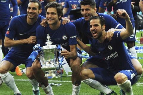 Chelsea's Davide Zappacosta, left, Chelsea's Marcos Alonso, 2nd left, Chelsea's Alvaro Morata and Chelsea's Cesc Fabregas, right, celebrate with the trophy after winning the English FA Cup final soccer match between Chelsea v Manchester United at Wembley stadium in London, England, Saturday, May 19, 2018. (AP Photo/Rui Vieira)