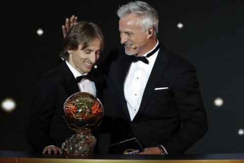 Real Madrid's Luka Modric, left, poses with David Ginola after receiving the Ballon d'Or award during the Golden Ball award ceremony at the Grand Palais in Paris, France, Monday, Dec. 3, 2018. Awarded every year by France Football magazine since Stanley Matthews won it in 1956, the Ballon d'Or, Golden Ball for the best player of the year will be given to both a woman and a man. (AP Photo/Christophe Ena)