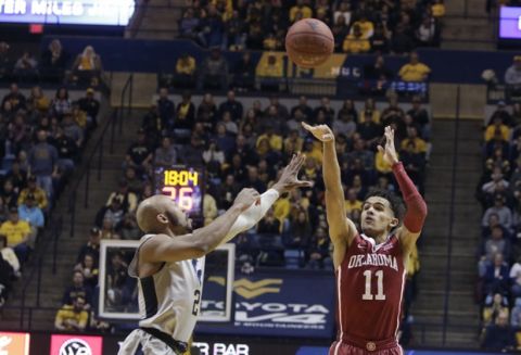 Oklahoma guard Trae Young (11) shoots while being defended by West Virginia guard Jevon Carter (2) during the first half of an NCAA college basketball game Saturday, Jan. 6, 2018, in Morgantown, W.Va. (AP Photo/Raymond Thompson)