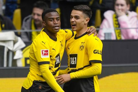 Dortmund's Youssoufa Moukoko, leftt, celebrates with his teammate Watjen Kjell-Arik after he scored his side's first goal during the German Bundesliga soccer match between Borussia Dortmund and Augsburg, in Dortmund, Saturday, May 4, 2024. (AP Photo/Martin Meissner)