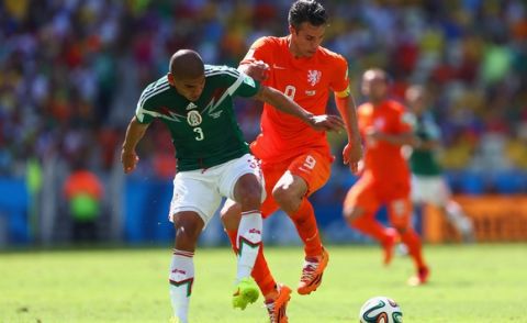 FORTALEZA, BRAZIL - JUNE 29: Carlos Salcido of Mexico challenges Robin van Persie of the Netherlands during the 2014 FIFA World Cup Brazil Round of 16 match between Netherlands and Mexico at Castelao on June 29, 2014 in Fortaleza, Brazil.  (Photo by Michael Steele/Getty Images)