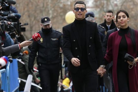 Cristiano Ronaldo arrives at the court in Madrid on Tuesday, Jan. 22, 2019. Cristiano Ronaldo is expected to plead guilty to tax fraud. The Juventus forward arrived in a black van, walked up some stairs leading to the court house and stopped to sign an autograph. The charges stem from his days at Real Madrid. (AP Photo/Manu Fernandez)